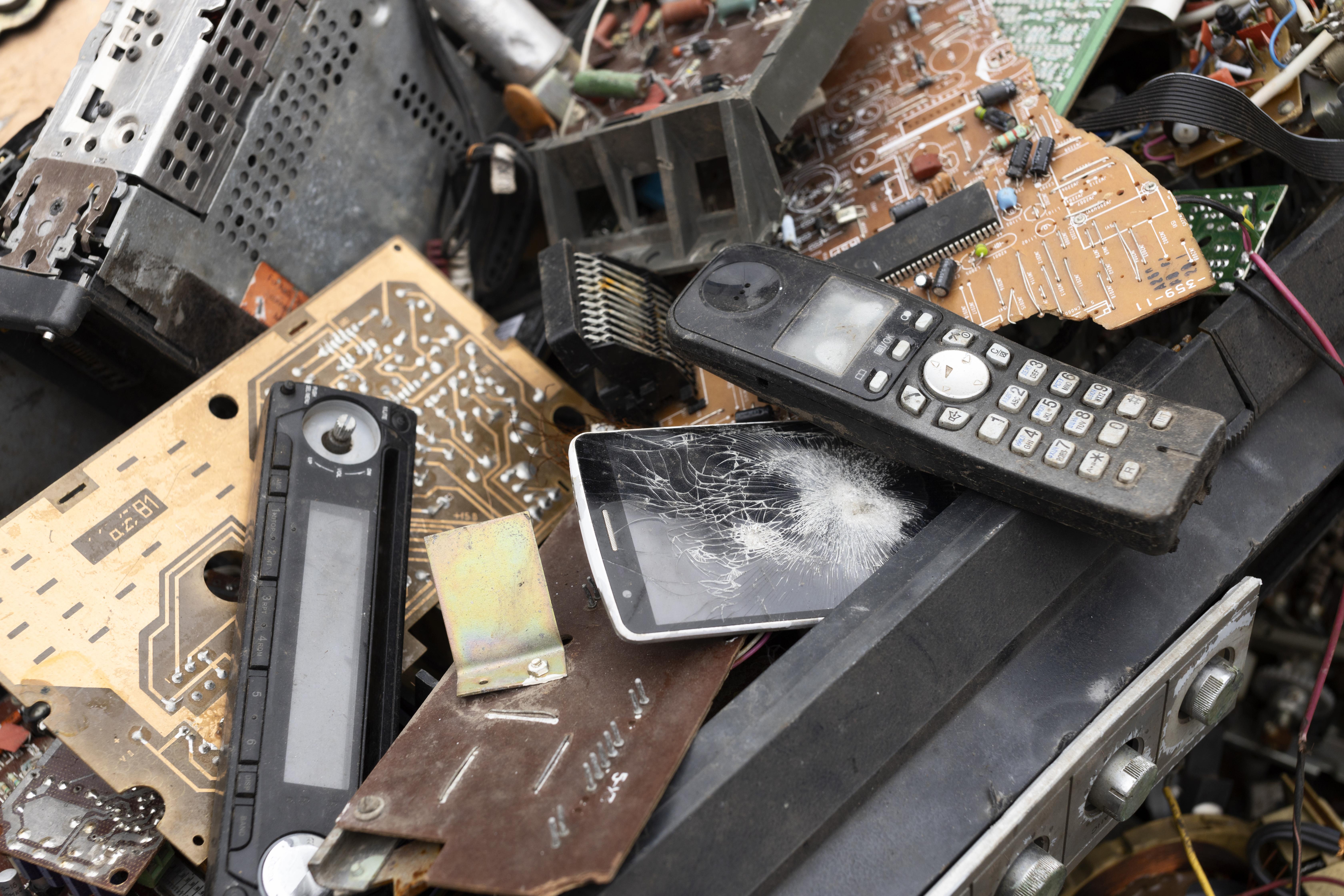 Pile of electrical waste, like telephones radios, remotes etc.
